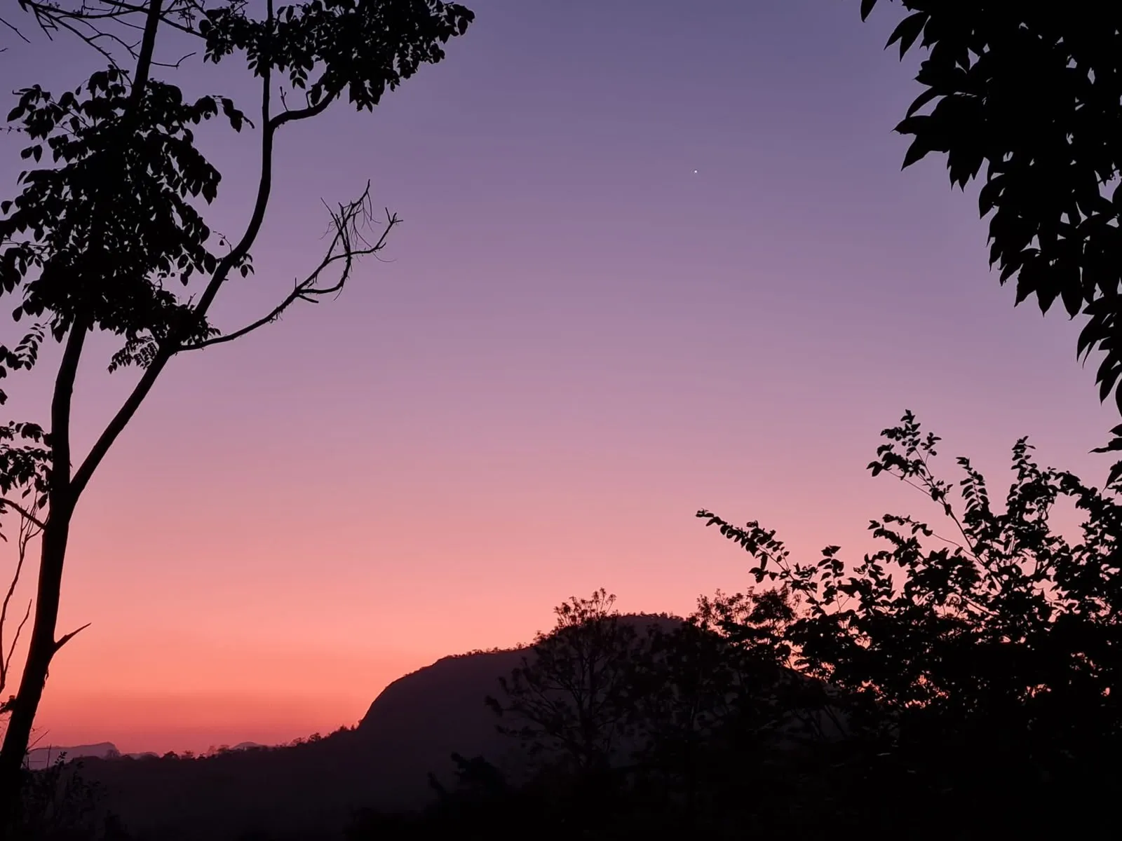 Dusk over a wooded hill